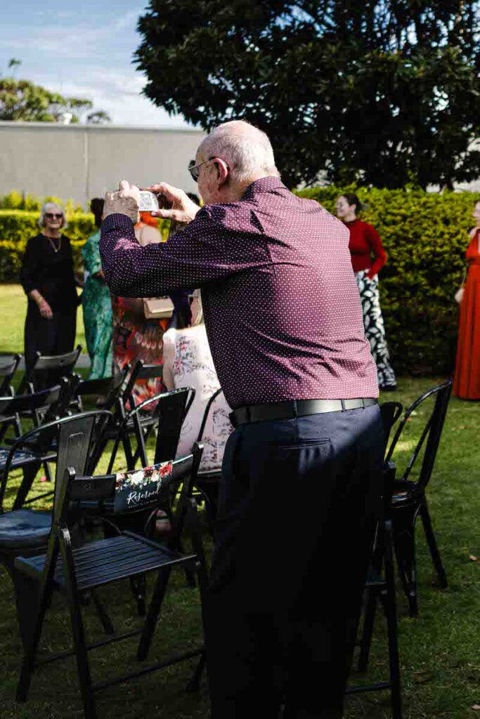 An elderly wedding guests taking a picture