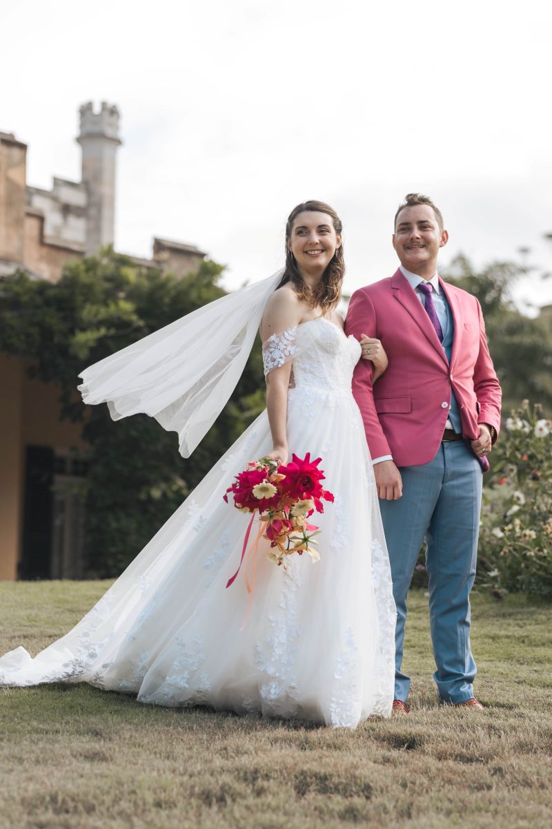 Bride and groom smiling on the lawn with the historic tower of Vaucluse House in the background—Sydney heritage wedding venue photographer capturing couple portraits